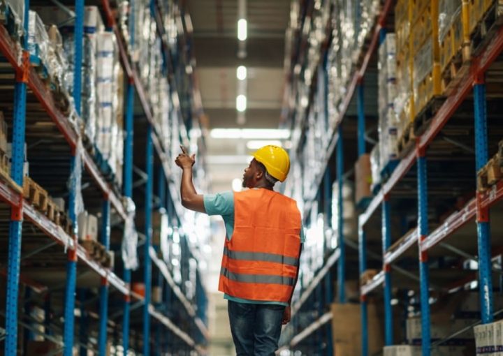 Warehouse worker inspecting inventory, representing efficient distribution channels and multichannel logistics strategies.